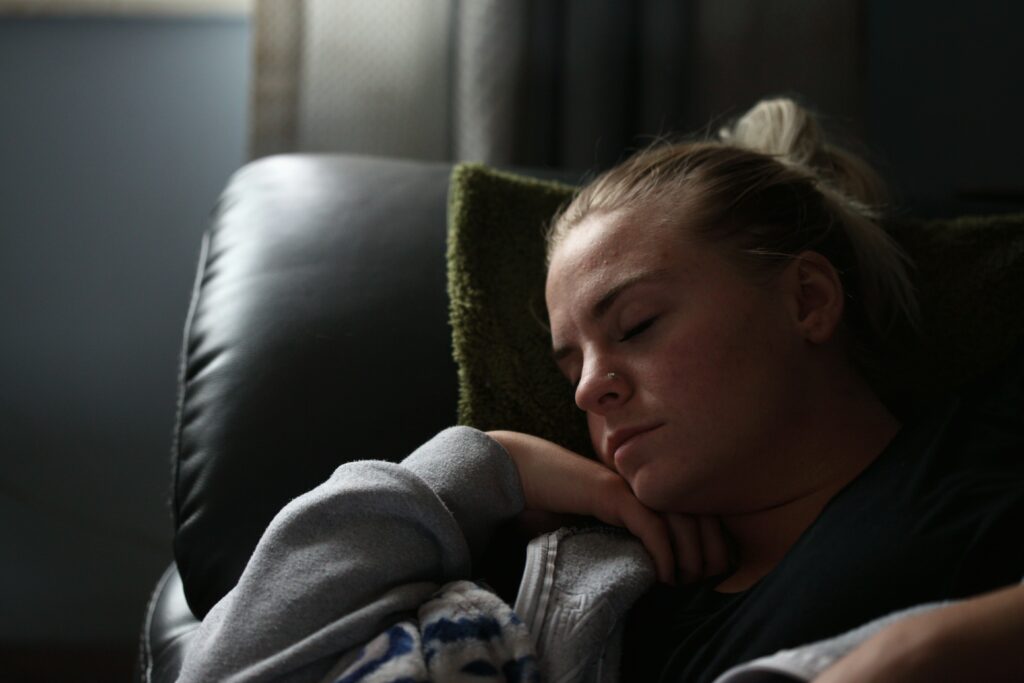 Woman sleeping on leather couch