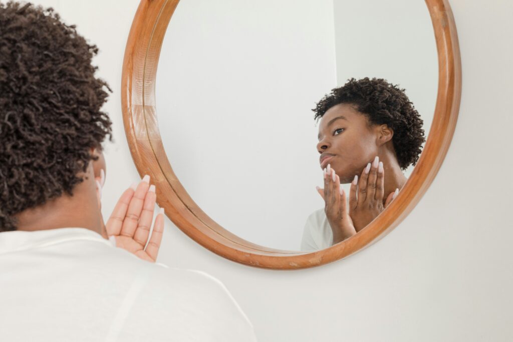 Woman looking at her skin in the mirror